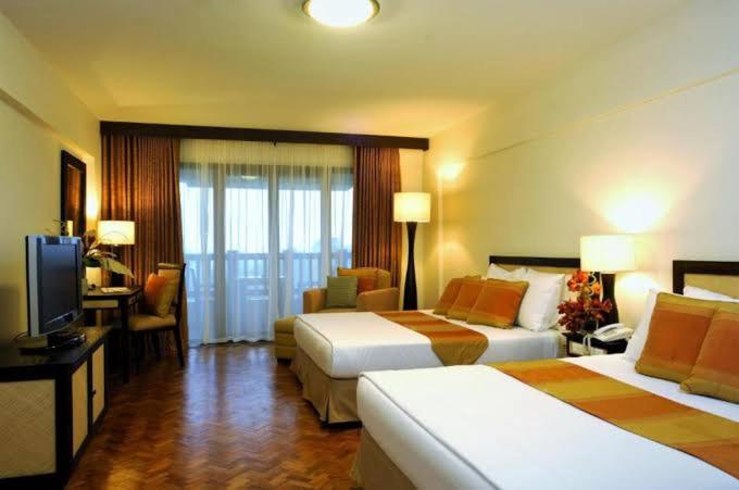 a hotel room with two beds and a television at Apo 201-Alta Vista De Boracay in Boracay