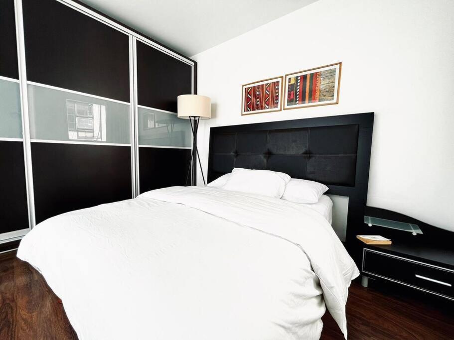 a bedroom with a white bed and a black headboard at Condesa Residence Amsterdam 303 Exquisite 1 Bedroom, 1 Bathroom Residence on Amsterdam Avenue in Mexico City