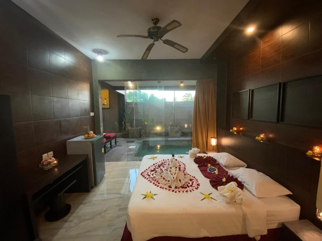 a bedroom with a bed with a cake on it at Bali Golden Elephant Boutique Villa in Jimbaran