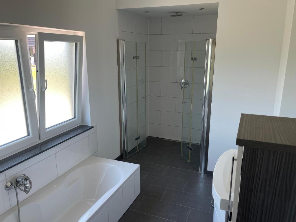 a bathroom with a bath tub and a shower at Penthouse Ob2 in Bad Essen