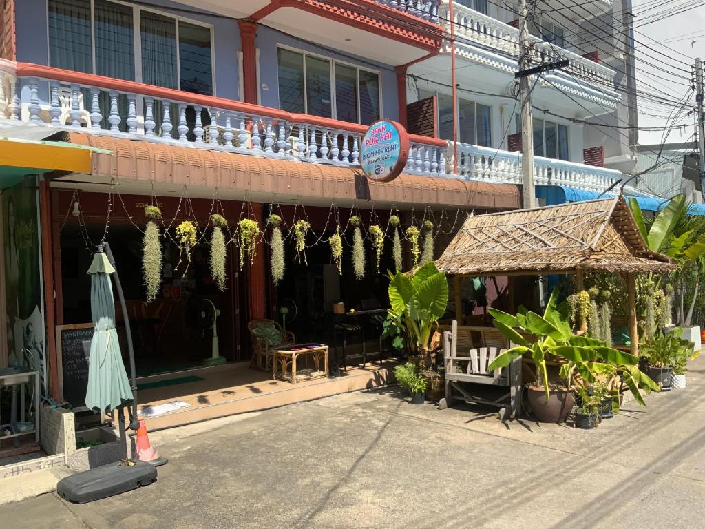 a building with an umbrella and plants in front of it at Ban Por Fai in Cha Am