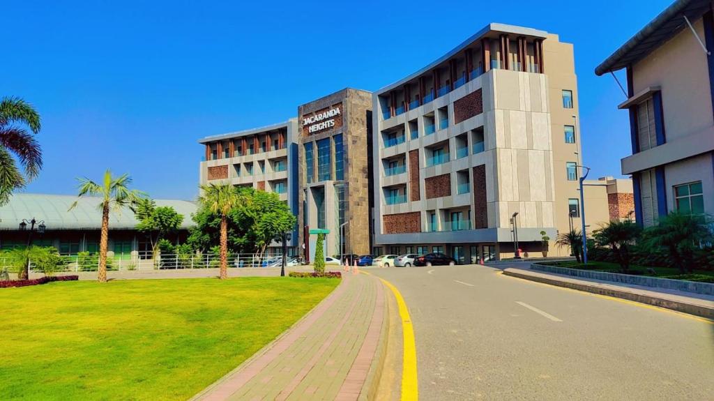 a large building with a road in front of it at Jacaranda Heights in Islamabad