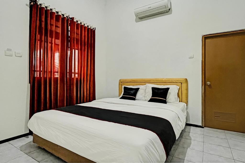 a bedroom with a large bed with two pillows at Capital O 1362 Ciliwung Guest House Syariah in Malang