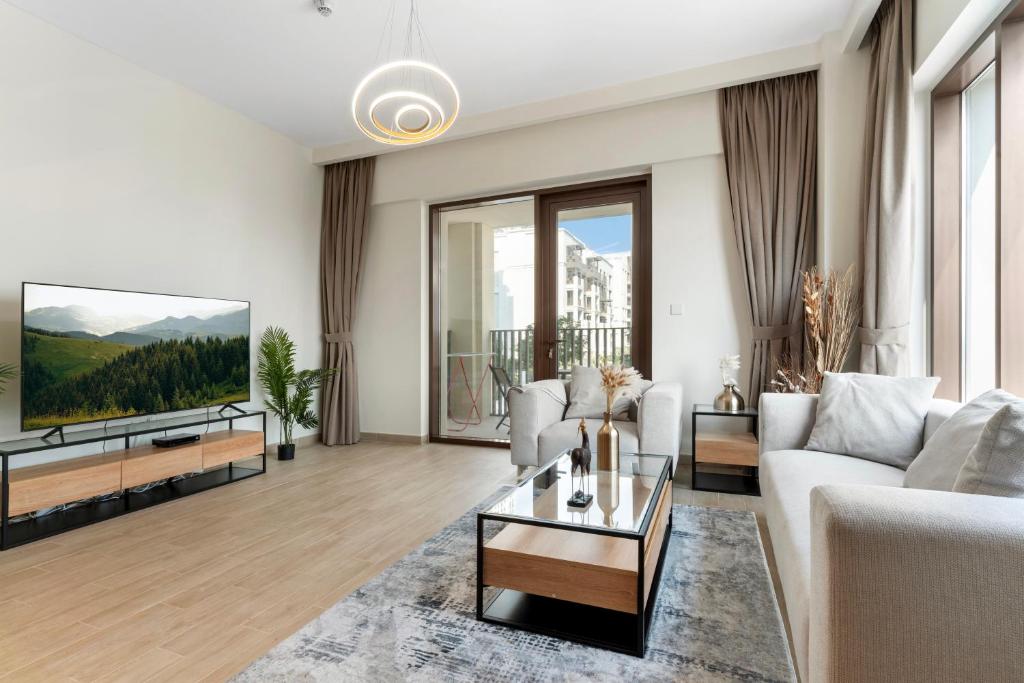 uma sala de estar com um sofá e uma televisão em Supreme Luxury 2BR Apartment em Dubai