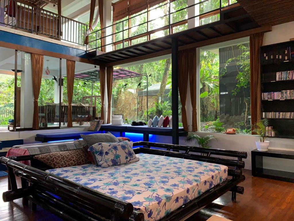 a bedroom with a bed in a room with windows at Large House with Swimming Pool-Griya Alcheringa in Bedoyo