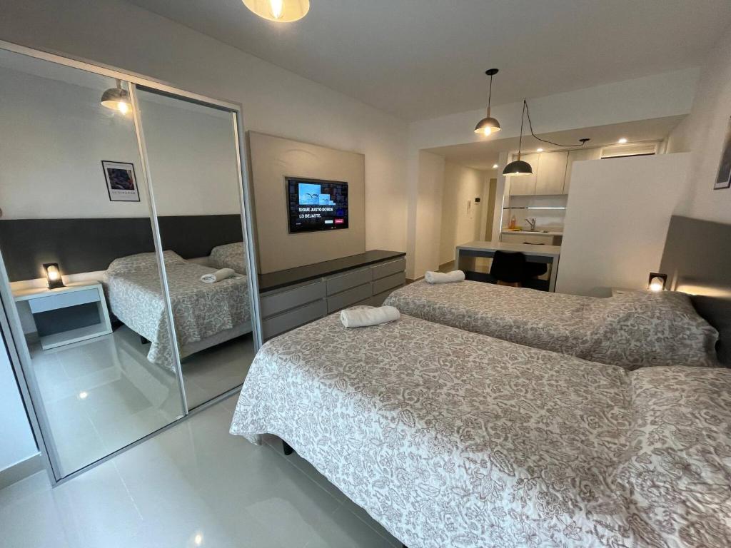 a hotel room with two beds and a television at Urban Luxury Studio Living in San Telmo num4649 in Buenos Aires