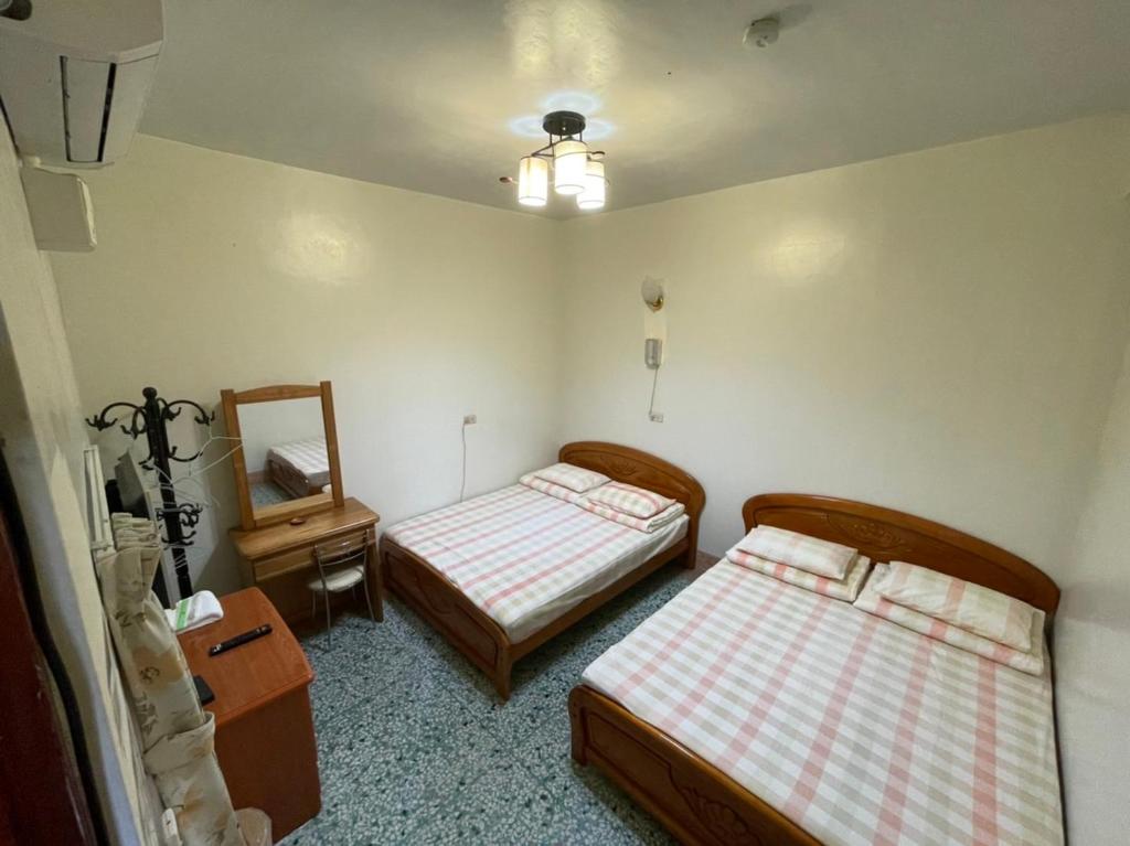 鹿谷的住宿－溪頭雅園民宿	 ，小房间设有两张床和镜子