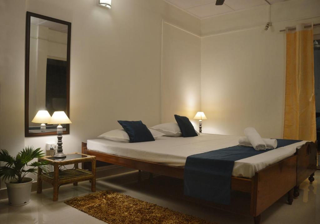 a bedroom with a large bed and a mirror at Upaja Ghar Homestay in Guwahati