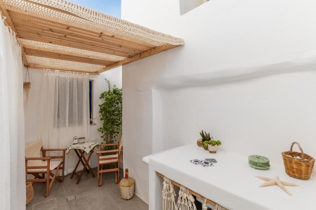 una cucina e una sala da pranzo con pareti bianche e soffitto in legno di Lithos a Kóstos