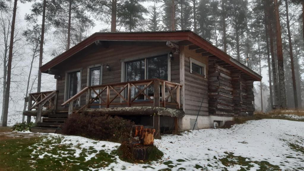 een blokhut in het bos in de sneeuw bij Jokiniemen Matkailu Cottages in Tölvä