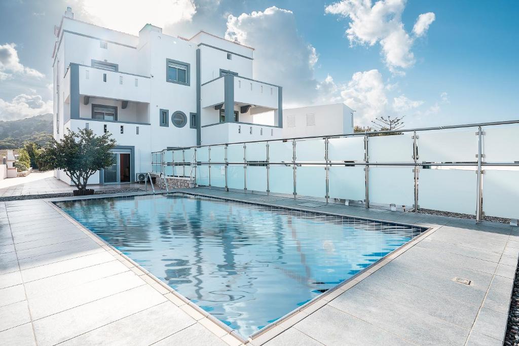 uma piscina em frente a um edifício branco em White Pearl Apolakkia 1 em Apolakkiá