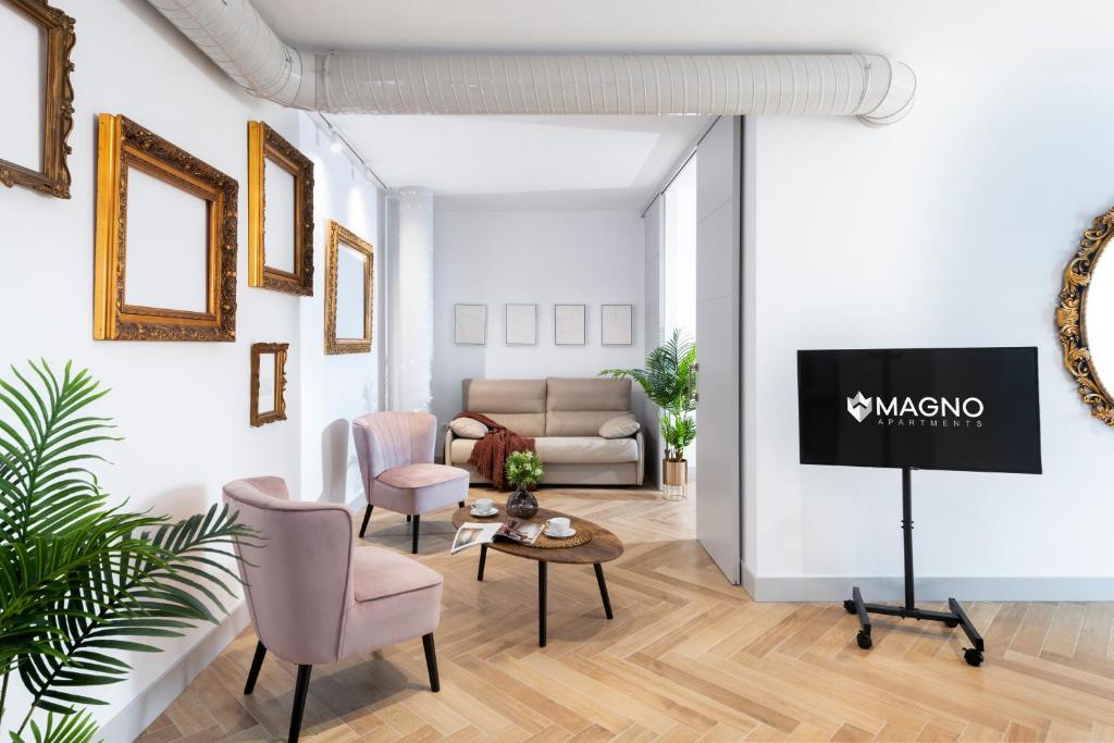 sala de estar con TV y sofá en Magno Apartments Zaragoza, en Sevilla