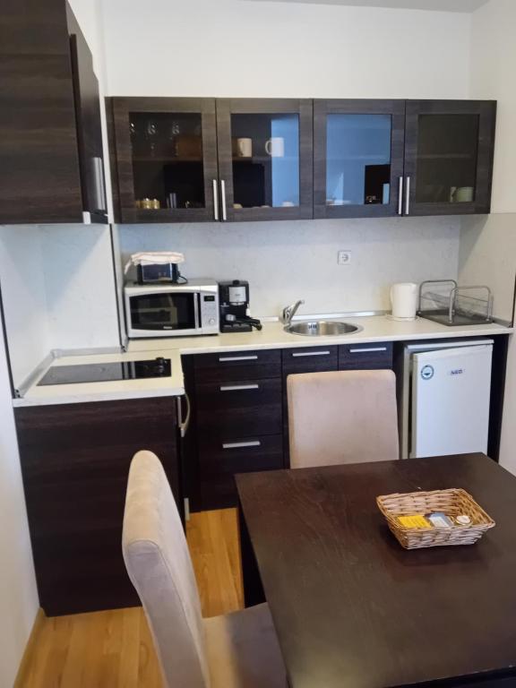 una pequeña cocina con mesa y microondas en TES Rila Park Apartments, en Borovets