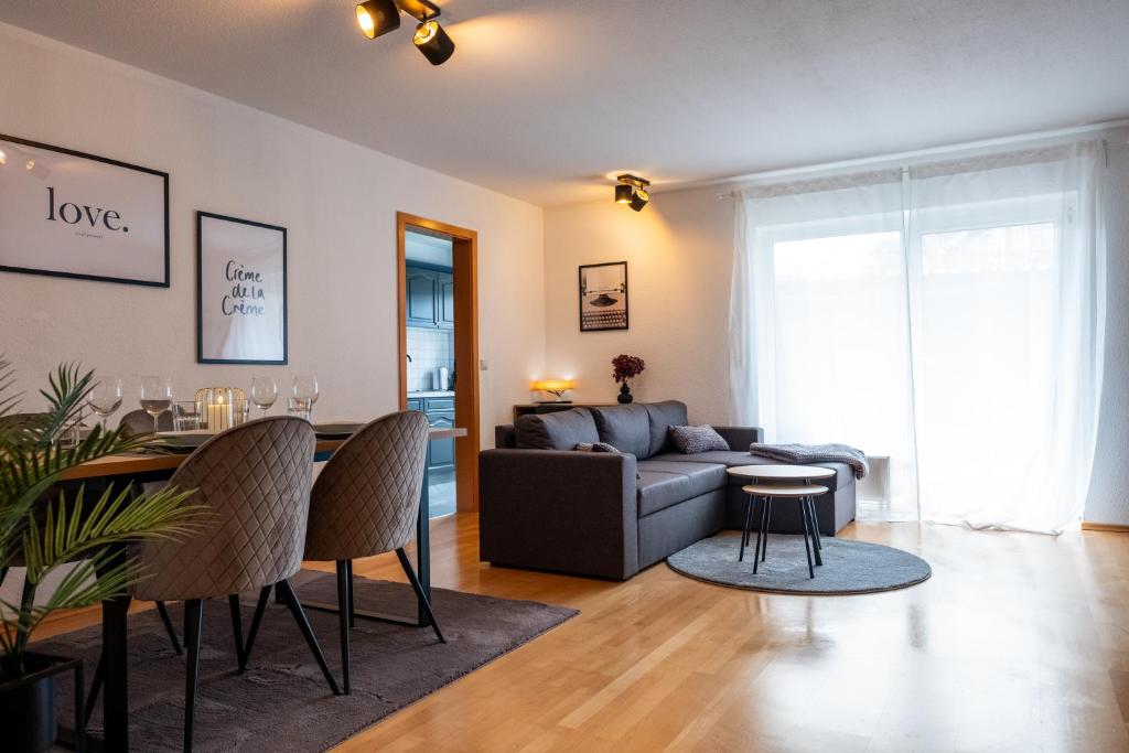 salon z kanapą i stołem w obiekcie Klassen Apartments! Zentral und bequem, entdecken Sie Bad Schussenried w mieście Bad Schussenried