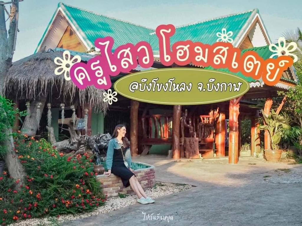 a woman is walking in front of a store at ครูไสวโฮมสเตย์ 