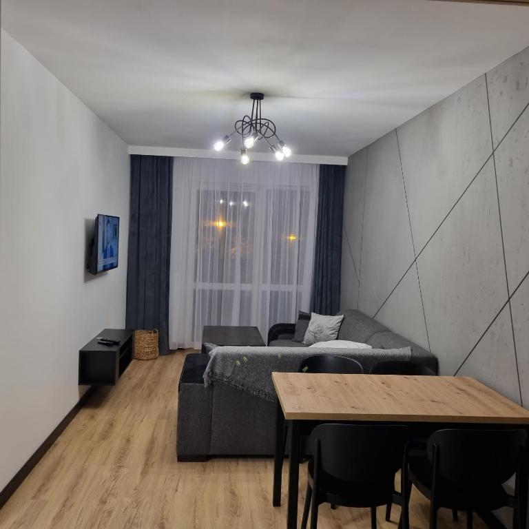 sala de estar con sofá y mesa en Komfortowy apartament en Toruń