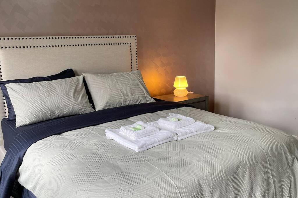 dwa ręczniki na górze łóżka z lampką w obiekcie Family Home in Riverdale Village Town Tarneit w mieście Tarneit
