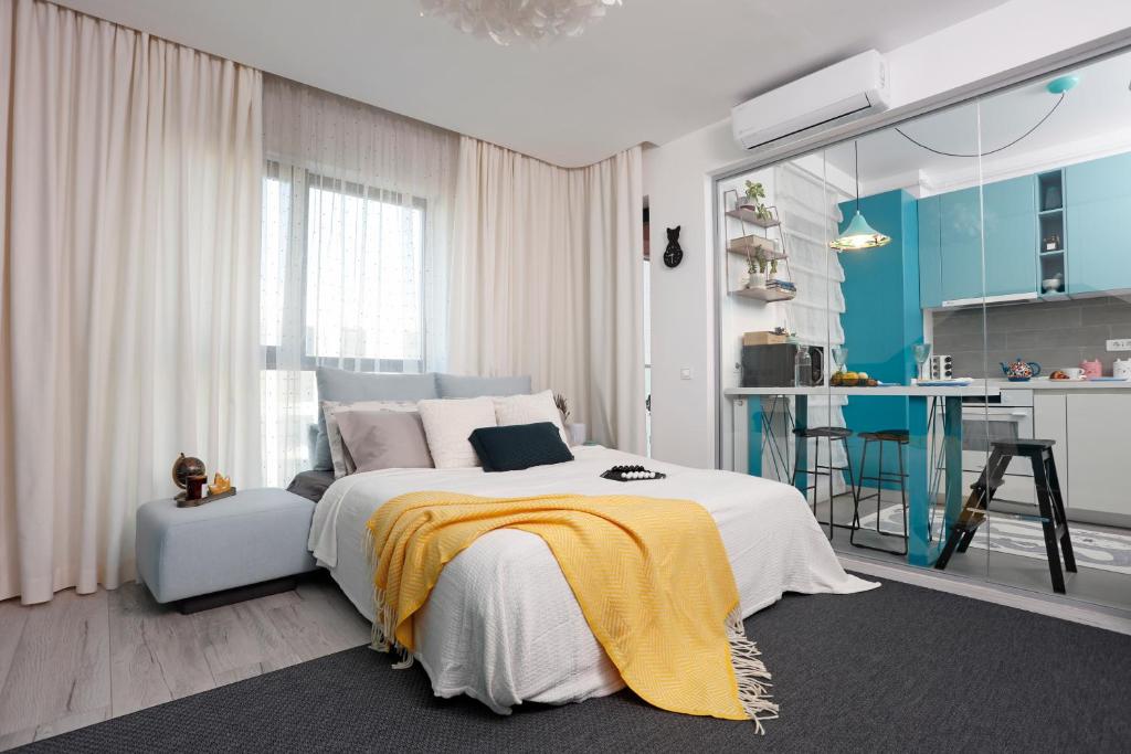 Un dormitorio con una cama con una manta amarilla. en Studio Alegre, en Bucarest