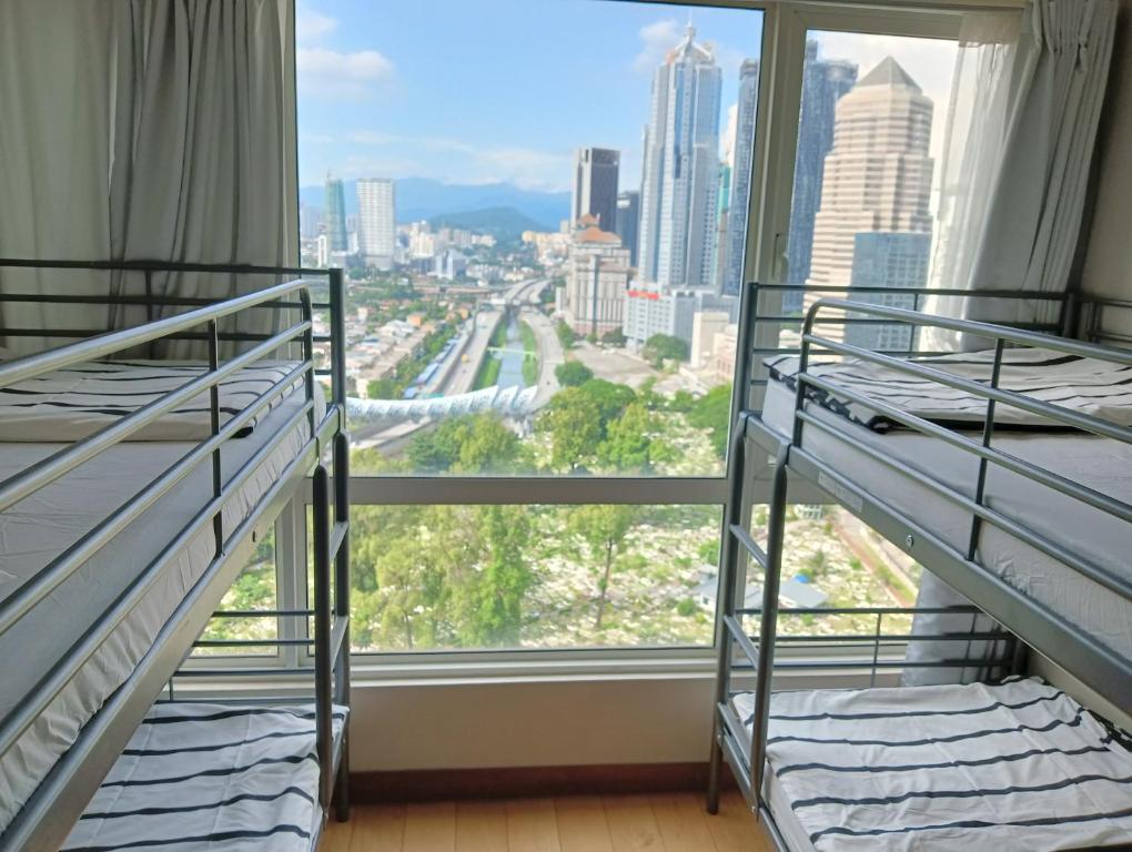 2 letti a castello in una camera con una grande finestra di ARH Home KLCC a Kuala Lumpur