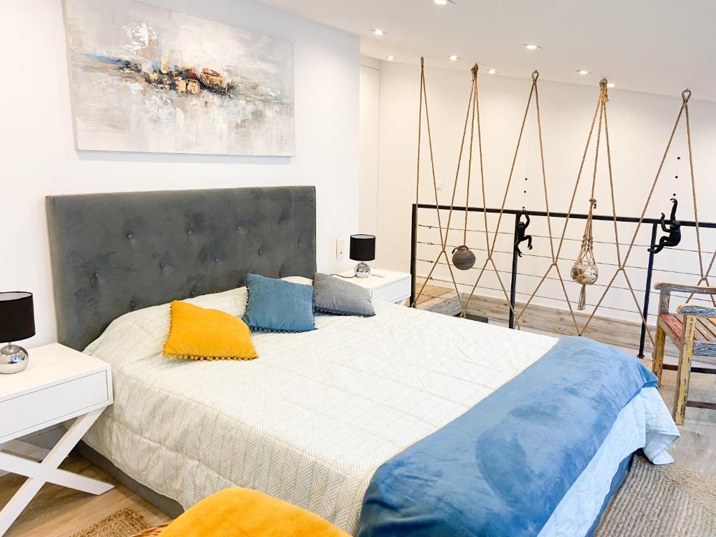 a bedroom with a large bed with blue and yellow pillows at Casa Eden in Ferragudo