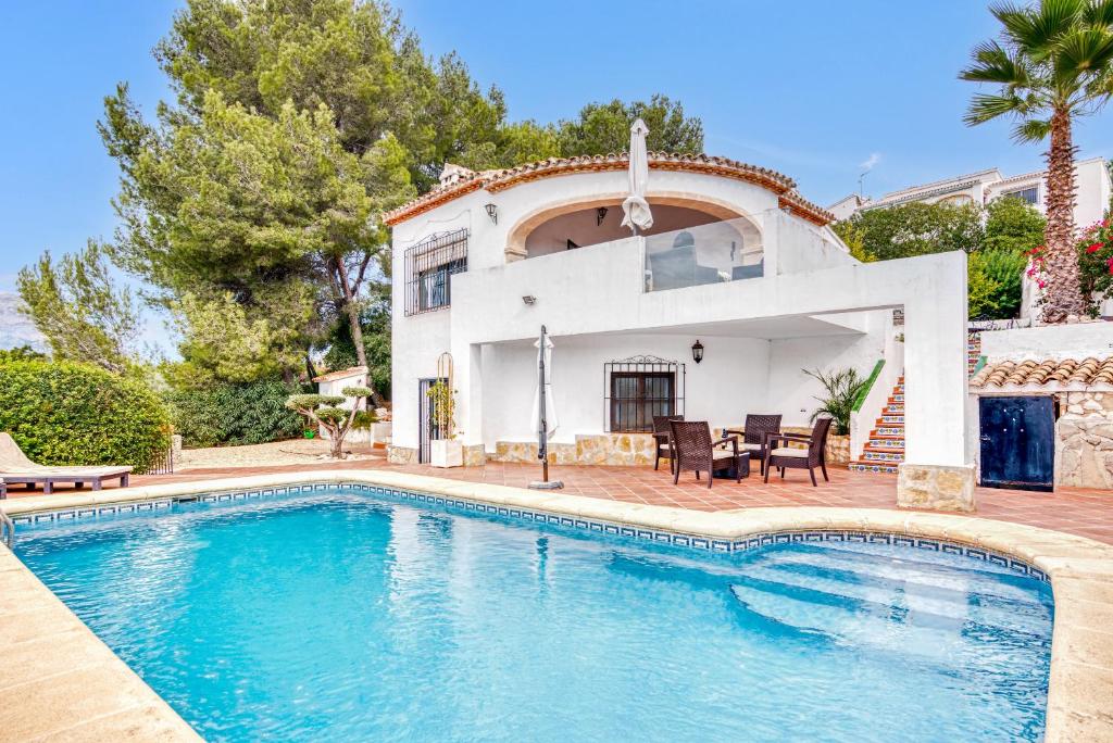 a villa with a swimming pool in front of a house at Villa up to 8 sleeps 4 bedrms 2 in Jávea