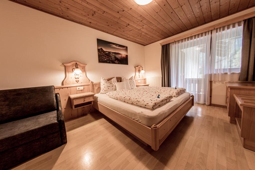 1 dormitorio con cama y ventana en Mösslhof App Garten, en San Vito