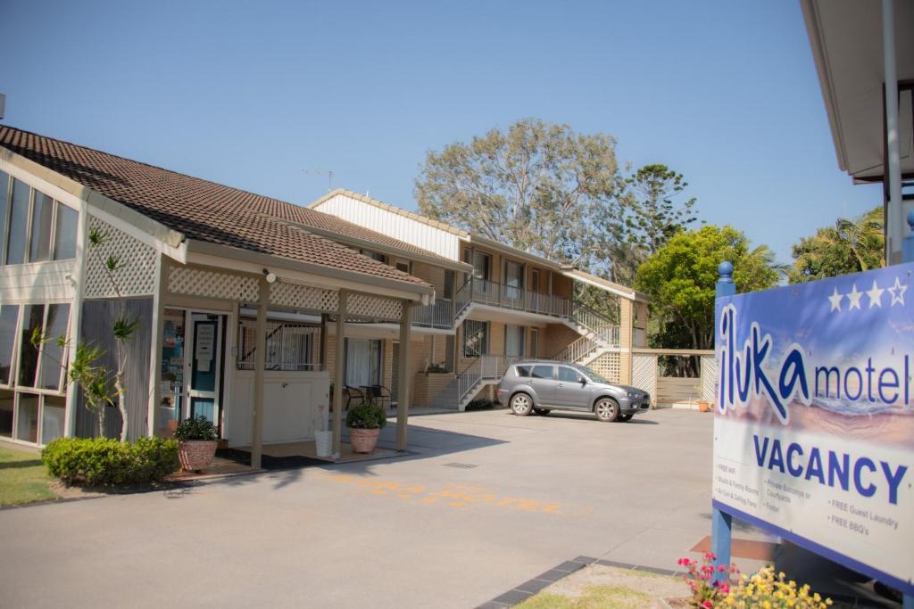 a sign in a parking lot in front of a motel at Iluka Motel in Iluka