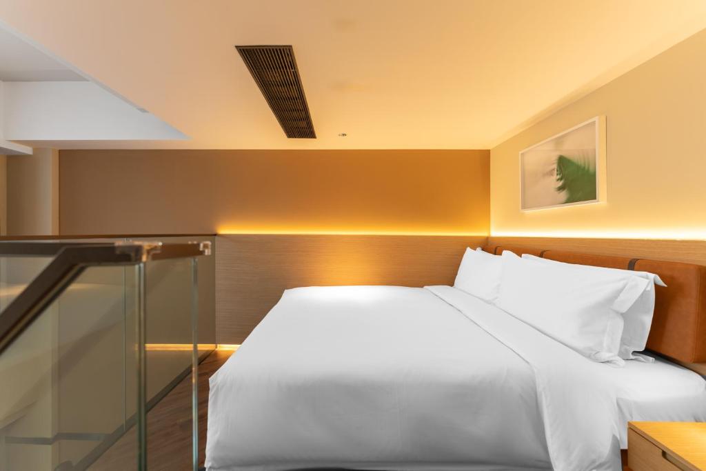 Postel nebo postele na pokoji v ubytování Mia Hotel - Shanghai Xuhui Jiaotong University