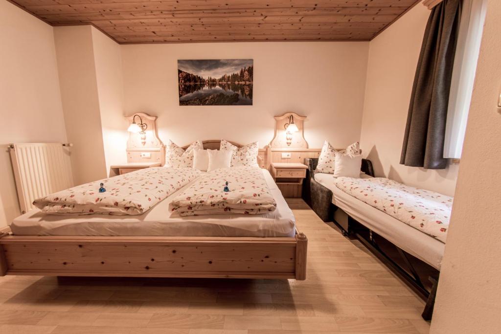 two beds in a bedroom with two lamps at Mösslhof App Laite in San Vito