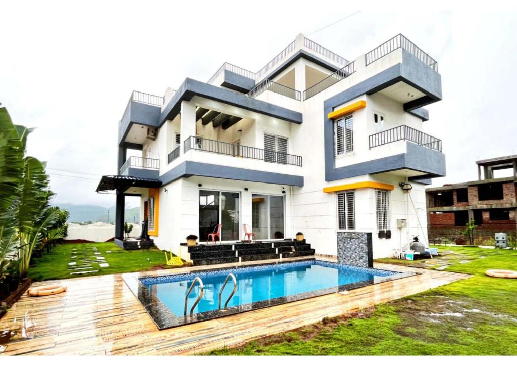 a house with a swimming pool in front of it at Magnite Villa in Lonavala