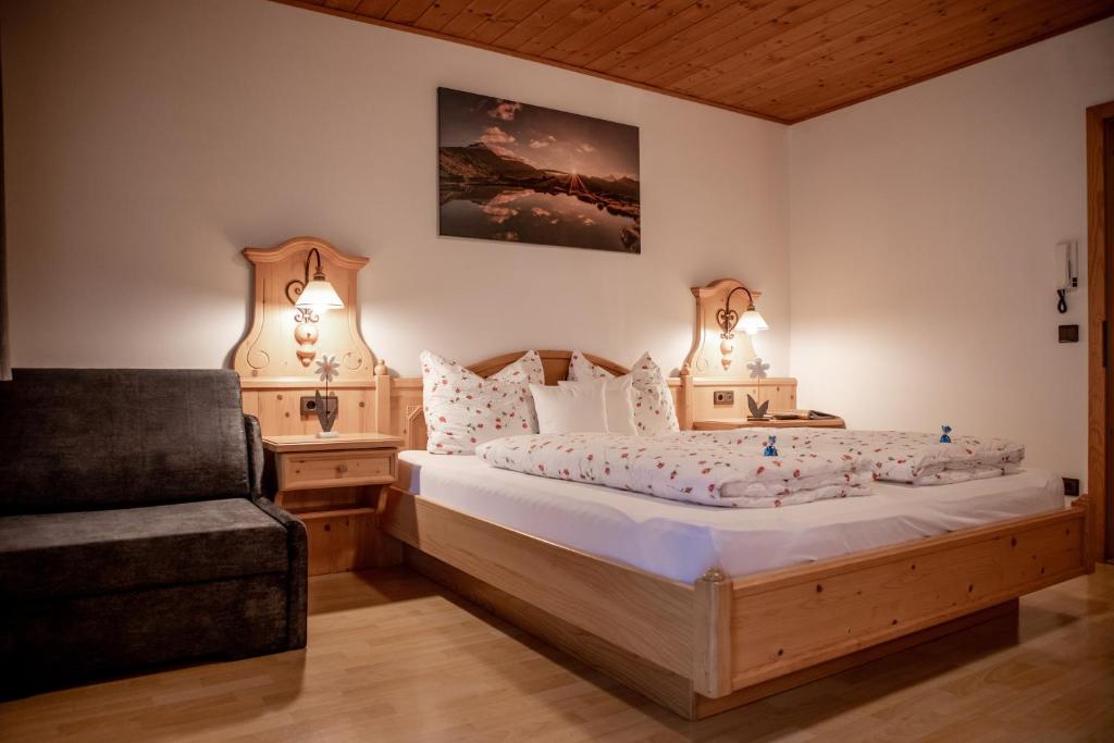 a bedroom with a bed with two lamps and a chair at Mösslhof App Wiese in San Vito