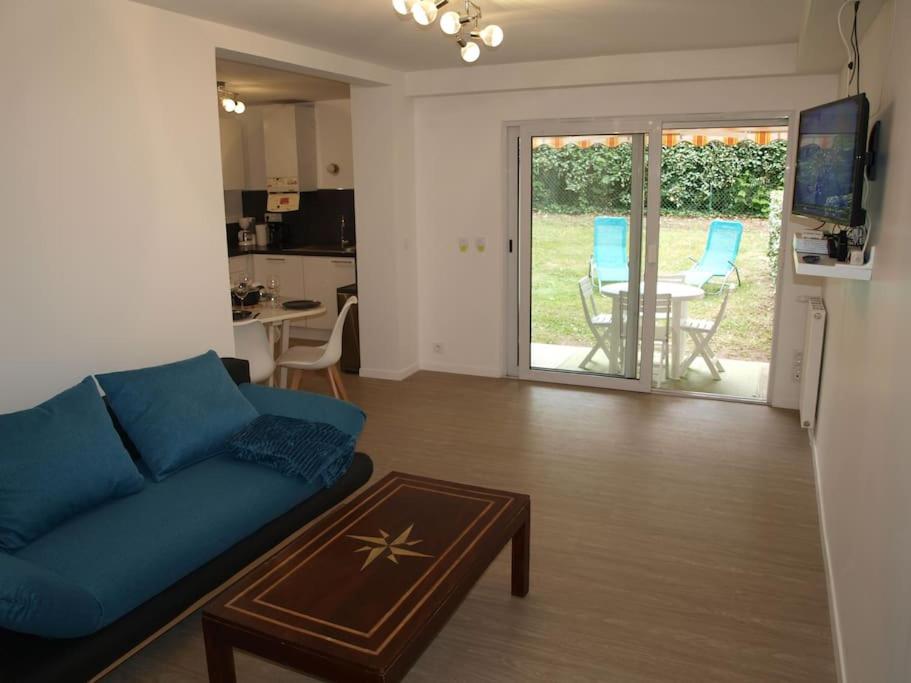 - un salon avec un canapé bleu et une table dans l'établissement Appartement terrasse jardin rive gauche du port, à Vannes