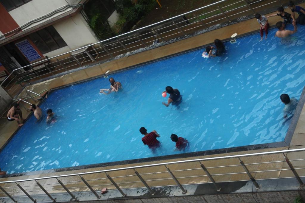 a group of people swimming in a swimming pool at Antique Home Stay in Daman