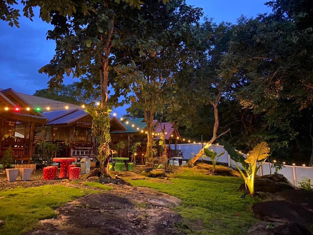 a restaurant lit up at night with lights at ปลายเขื่อนแคมป์ปิ้ง บ้านเรือไทย in Sirindhorn