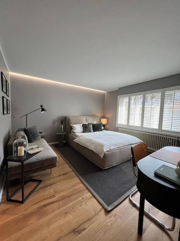 a bedroom with a bed and a couch and a table at Premium Apartment an der Stadtmauer im EG in Paderborn