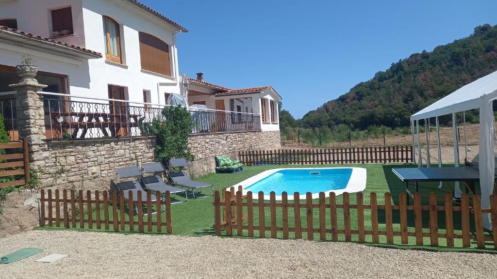 Montanyola的住宿－Casa Rural Aliberch，游泳池周围设有围栏的房子