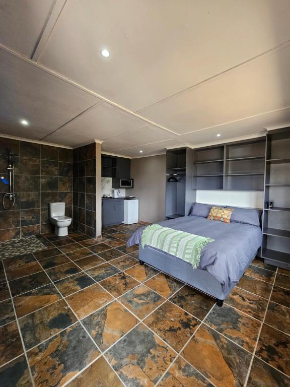 a bedroom with a bed and a tiled floor at SavannaSkies Stays in Hillcrest