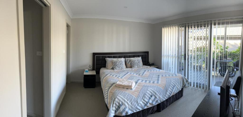 a bedroom with a bed with a striped blanket at Gosford Townhouse in Gosford