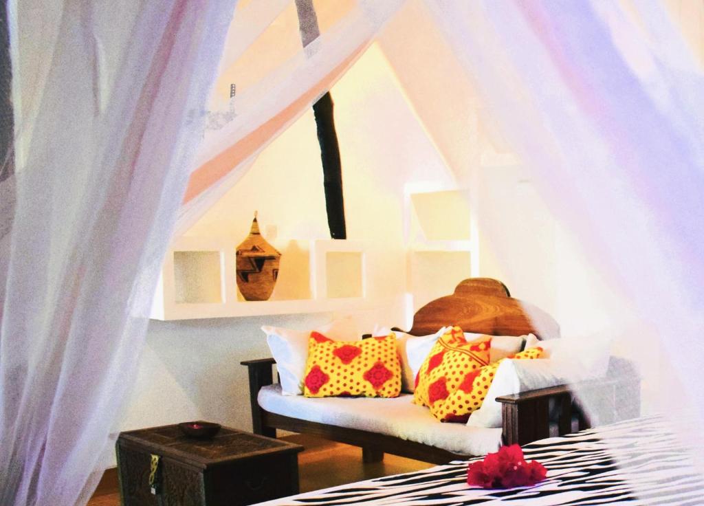 ein Schlafzimmer mit einem Bett mit bunten Kissen darauf in der Unterkunft Zanzibar Dream Lodge in Bwejuu