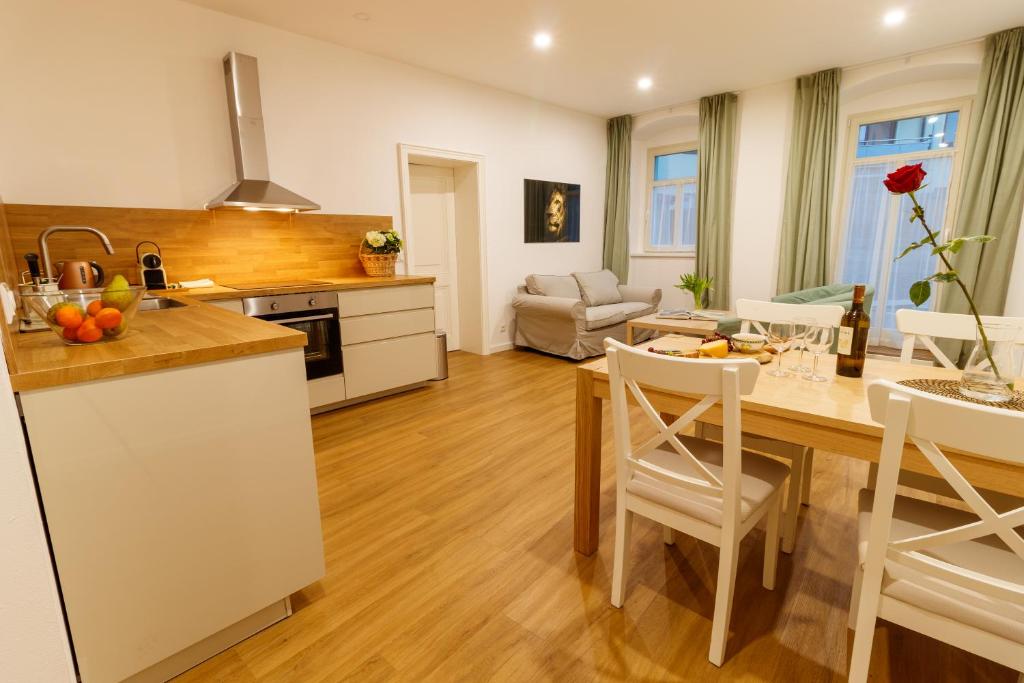 eine Küche und ein Wohnzimmer mit einem Tisch und Stühlen in der Unterkunft Apartmany Tachov Garden House in Tachov