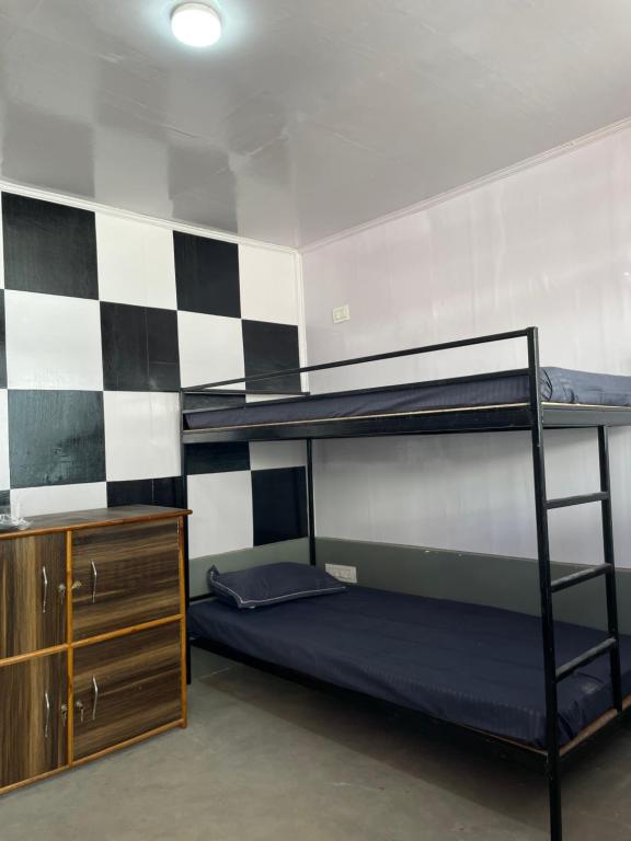 PedongにあるRilassare Stays Hostelの二段ベッド2台とドレッサーが備わる客室です。