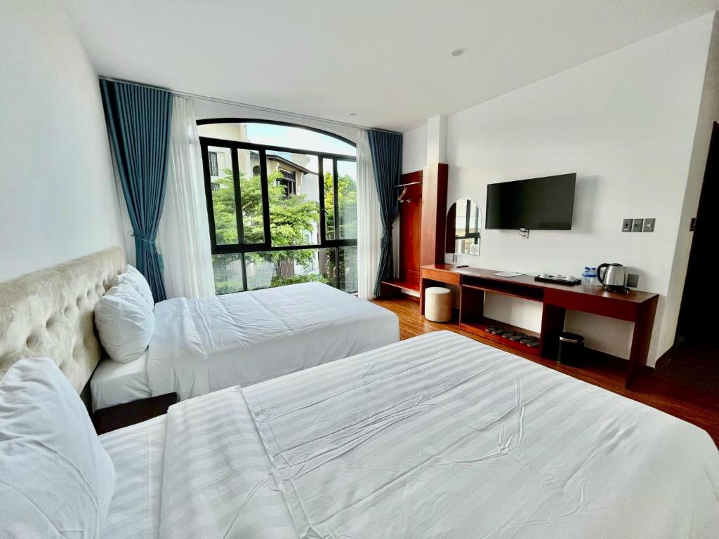 pokój hotelowy z 2 łóżkami i telewizorem w obiekcie Ban Me Central Hotel 2 w mieście Buôn Ma Thuột