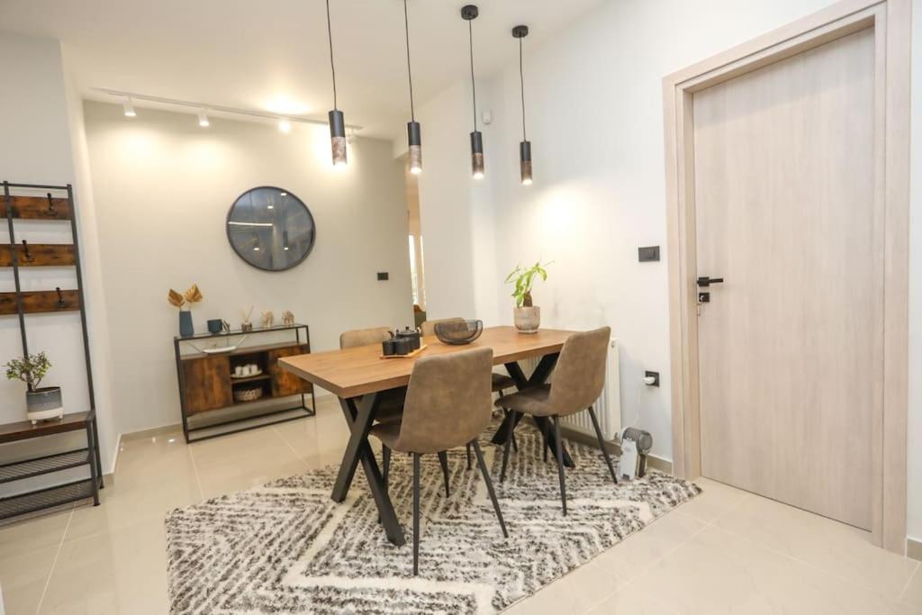 Modern and Luxury apartment في أثينا: غرفة طعام مع طاولة وكراسي على سجادة