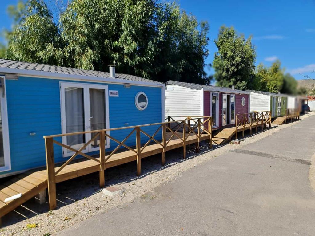 una fila de trenes blancos y azules estacionados en una estación en Camping Costa Blanca, en El Campello