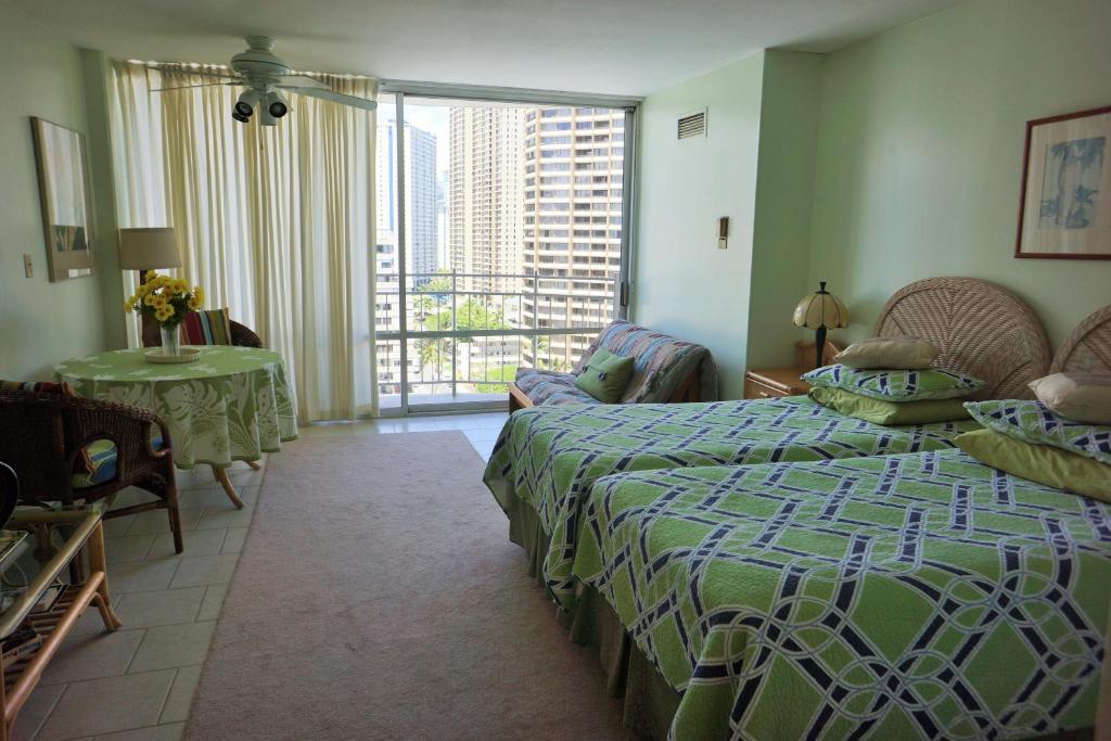 a bedroom with a bed and a living room with a window at Waikiki Studio at Ilikai Marina - great apartment by the beach - see low end price! in Honolulu