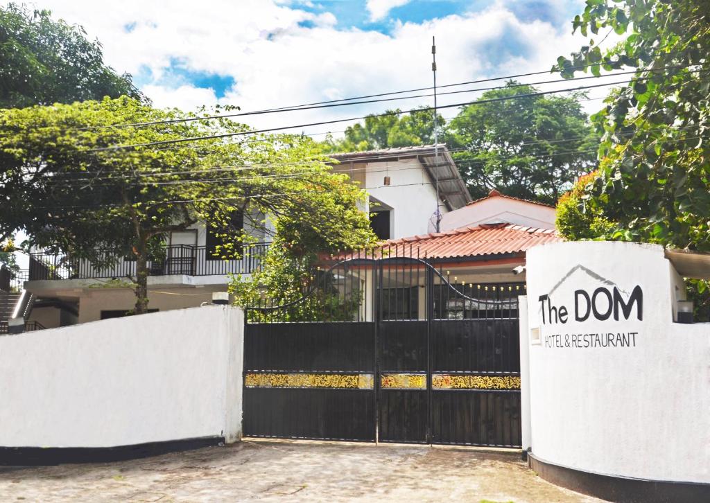 a sign on a fence in front of a house at The Dom hotel & restaurant in Ahangama