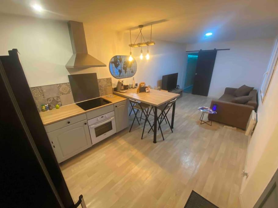 cocina y sala de estar con mesa y sofá en Appartement plain-pied, en Migné-Auxances