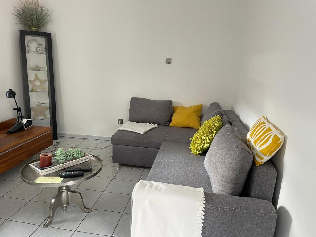uma sala de estar com um sofá cinzento e uma mesa em Vida Real Estate Feucht em Feucht