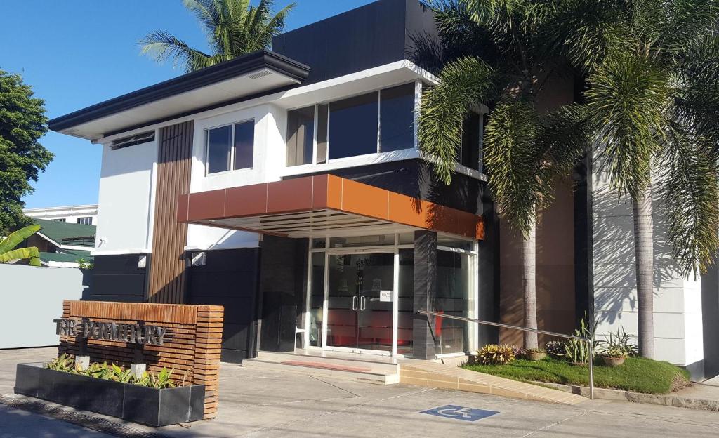 un bâtiment avec des palmiers en face de celui-ci dans l'établissement Harimariz Dormitory Official, à Dumaguete