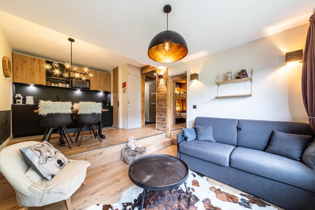 un salon avec un canapé bleu et une table dans l'établissement Le Bouquetin - IMMODREAMS - Avoriaz, à Avoriaz